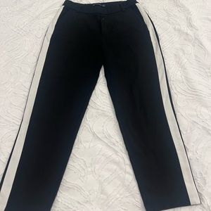 Black cropped pants with white stripes.